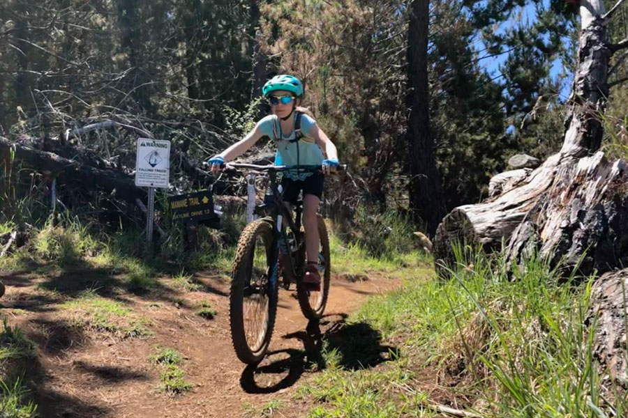 Young girl mountain biking in Maui with family