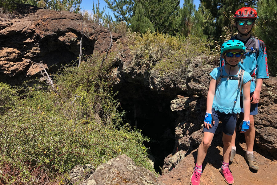 Checking out a cave while mountain biking with kids in Maui