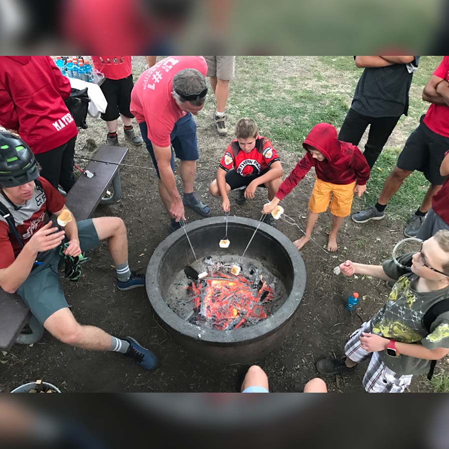 Roasting marshmallows for s'mores during a team practice.