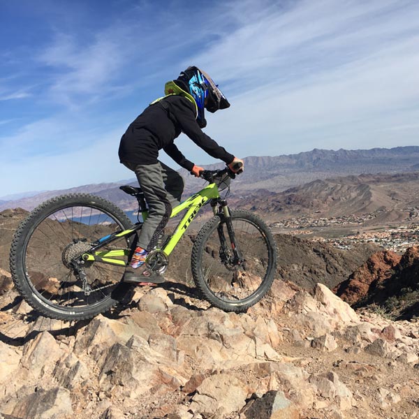 Kid with protective neck brace on downhill mountain bike trail - Bootleg Canyon