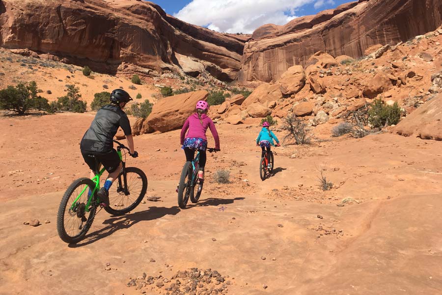 Ginger and kids riding mountain bikes in the desert