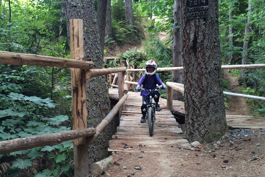 Crossing a bridge on Galbraith Mountain's beginner / family-friendly mountain bike trails